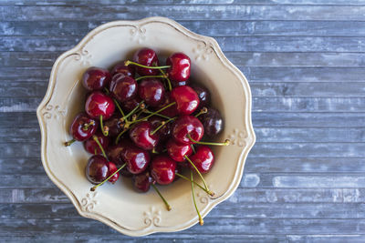 High angle view of cherries in vintage bowl on table