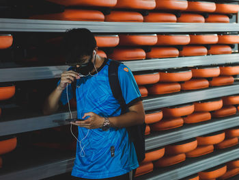 Full length of man standing against blue wall