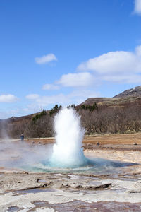 Scenic view of waterfall against sky