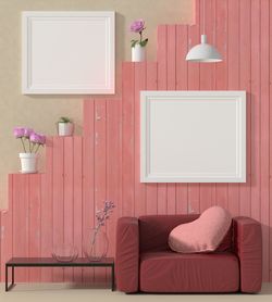 Empty chair against pink wall at home