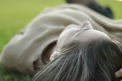 Close-up of woman lying on field