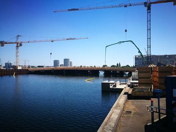 Construction site by river against sky