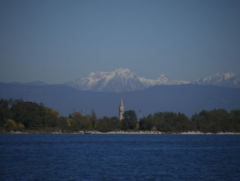 Scenic view of sea by buildings against clear sky