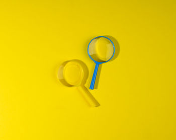 Two plastic magnifiers on a yellow background, top view