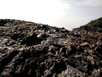 Close-up of rock formation on landscape against sky