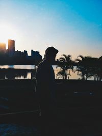 Silhouette of man in city against clear sky