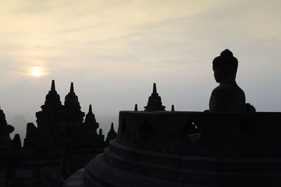 Silhouette of temple building against sky during sunset