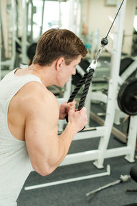 Young man exercising in gym