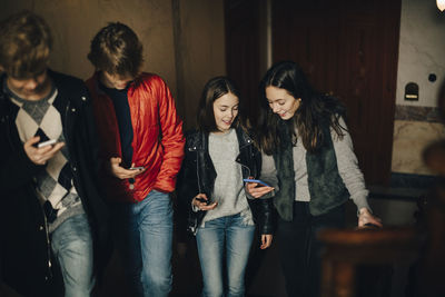 Full length of young woman using mobile phone