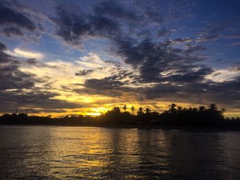 Scenic view of sea against dramatic sky during sunset