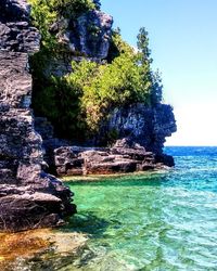 Scenic view of rock formation in sea against sky