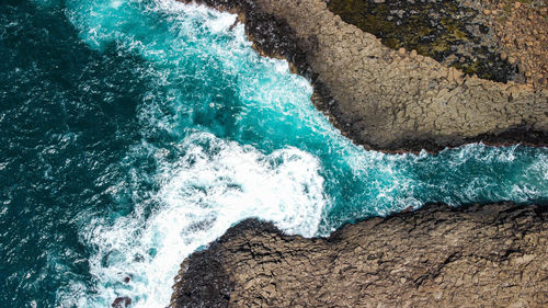 High angle view of waves splashing on rocks