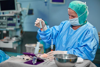 Midsection of female dentist holding dentures