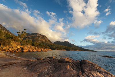 Scenic view of sea and mountains against sky