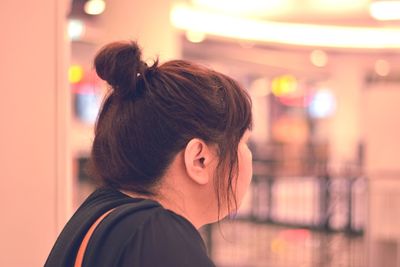 Close-up of woman with bun looking away