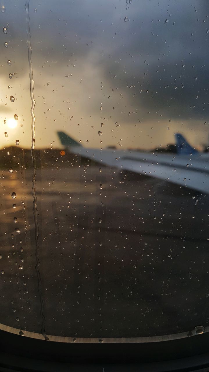 drop, glass - material, window, wet, water, transparent, mode of transportation, airplane, transportation, air vehicle, sky, rain, vehicle interior, no people, nature, sunset, close-up, indoors, glass, raindrop, rainy season