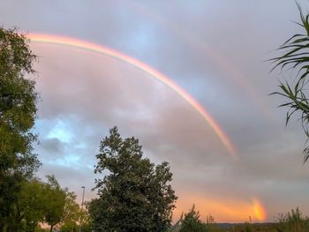 Low angle view of rainbow against sky at sunset