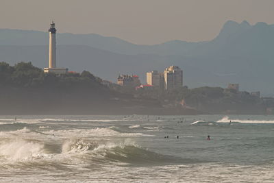 Scenic view of sea and buildings against sky during sunset