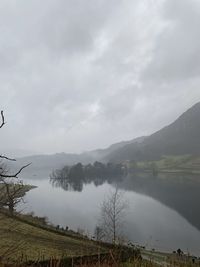 Scenic view of lake by mountains against sky
