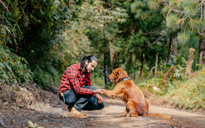 Side view of dog sitting on rock