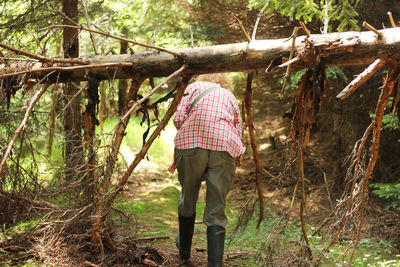 Rear view of woman walking at forest