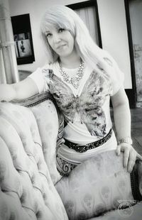 Portrait of smiling young woman sitting on sofa at home