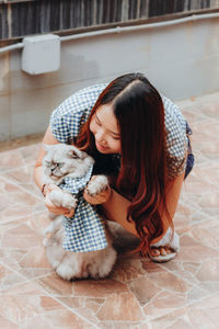 Woman playing with cat on floor