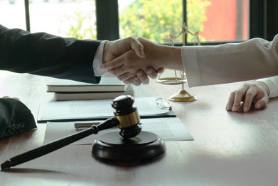 Close-up of hand holding electric lamp on table