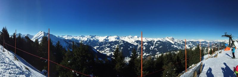 Scenic view of snowcapped mountains against blue sky