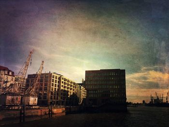 Buildings in city against cloudy sky