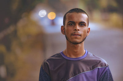 Portrait of young man standing on road