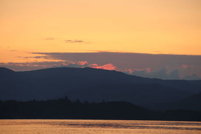 Scenic view of silhouette mountains against romantic sky at sunset