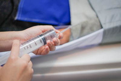 Cropped hands of doctor holding syringe in hospital 