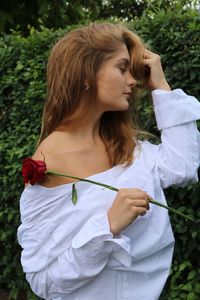 Close-up of woman with eyes closed standing against plants