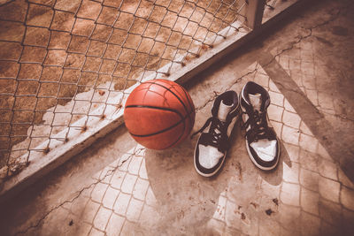 High angle view of basketball by shoes on court