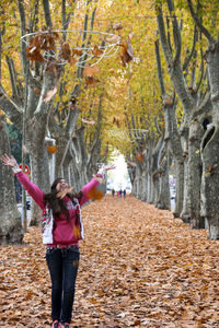 Woman standing by tree in park during autumn