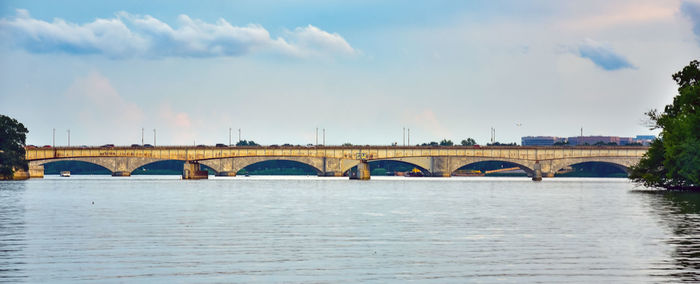 Arch bridge over river against sky