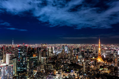 Illuminated cityscape against sky at night