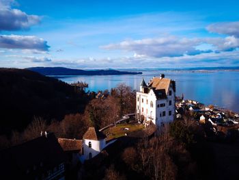 High angle view of buildings by sea against sky