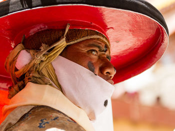 Close-up portrait of man wearing red hat