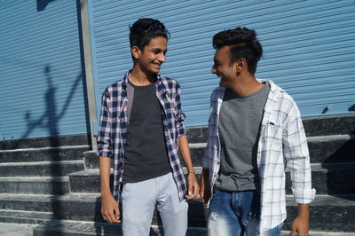 Young woman standing against wall