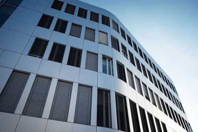 Low angle view of modern building against clear sky during sunny day