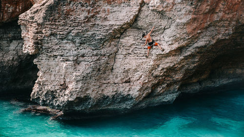 Rear view of man rock climbing