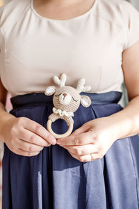 Midsection of woman holding toy