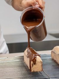 Cropped hand of person pouring coffee on table