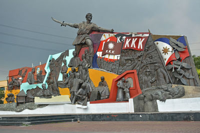 Low angle view of statues against sky