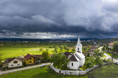 Houses by building against sky