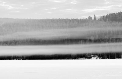 Scenic view of lake against sky during winter