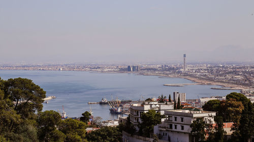 High angle view of buildings by sea against sky