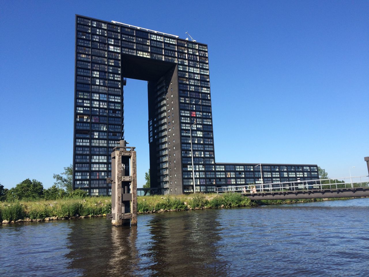 architecture, built structure, building exterior, water, waterfront, blue, clear sky, reflection, city, river, building, modern, rippled, tower, sky, day, low angle view, office building, no people, outdoors